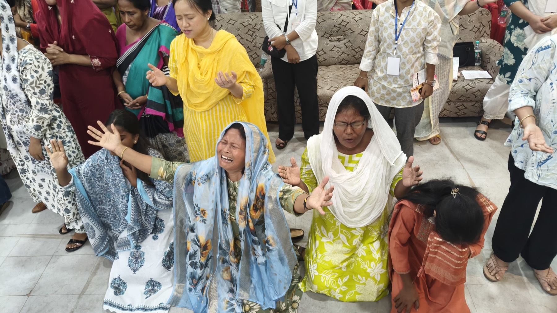 Women kneeling in prayer at the Encourage Conference